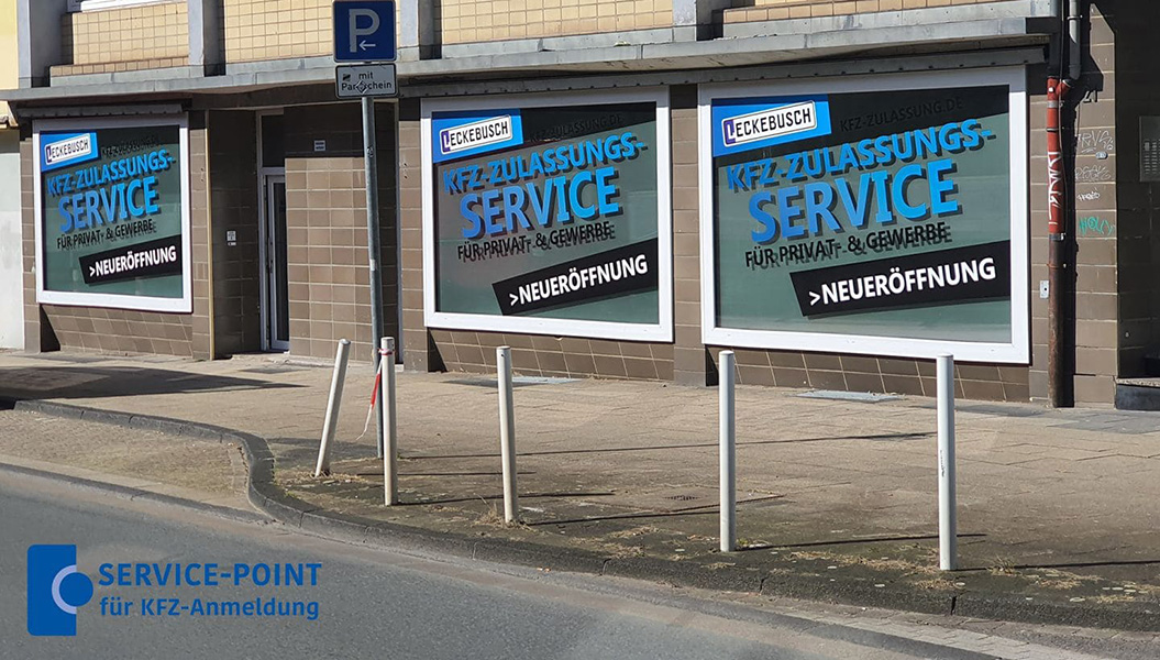 Große Werbeplakate für einen Kfz-Zulassungsservice mit blauem Text und Neueröffnung