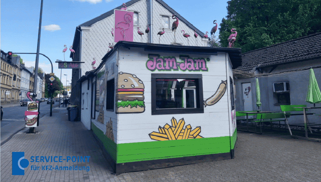 Kleiner weißer Imbiss mit bunten Burger und Pommes Motiven und rosa Flamingos