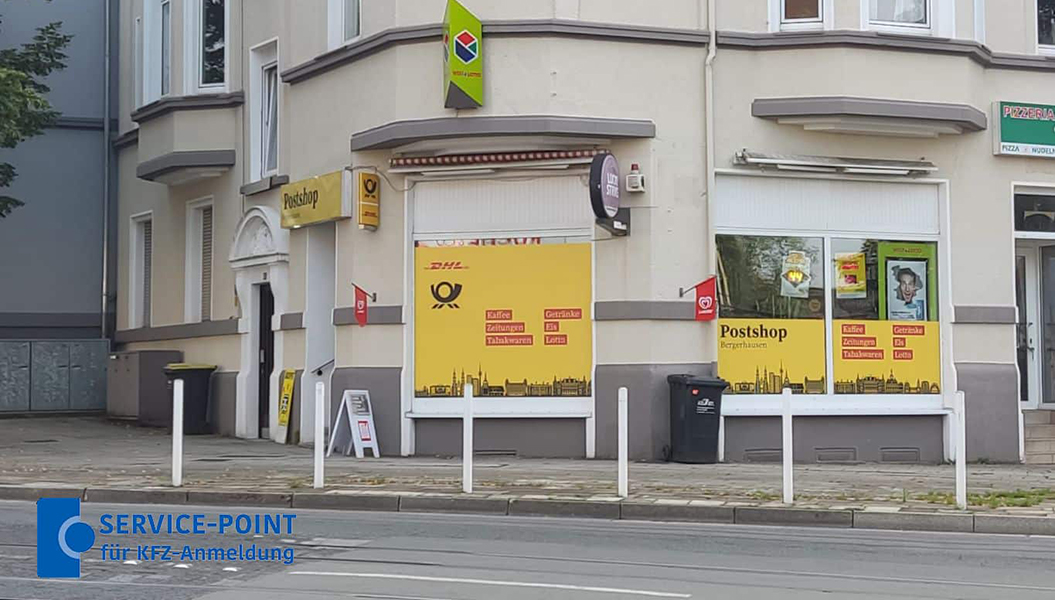 Eine Straßenecke mit Postshop in gelb und grau, auffällige Schilder und Stadtmotive