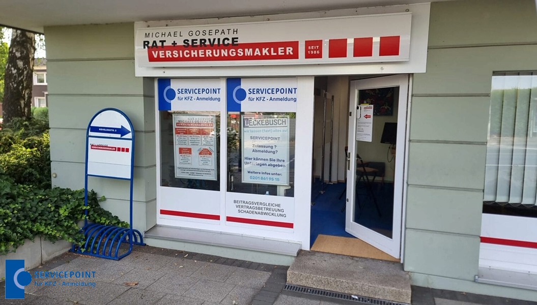 Ein Bürohaus mit Schildern zur Versicherungsberatung und einem offenen Eingang