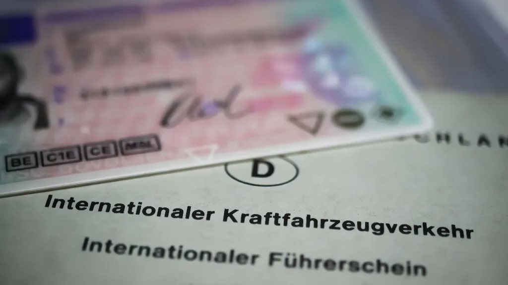 Ein deutscher Führerschein liegt auf einem internationalen Führerscheindokument